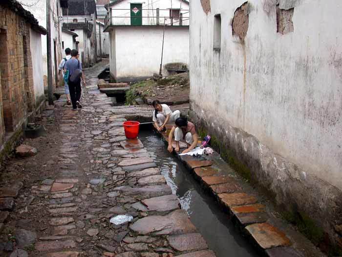 Villagers washing clothes at the ditch flowing through the village