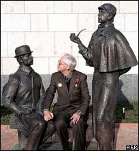 Man sitting between Sherlock Holmes and Dr. Watson in Moscow