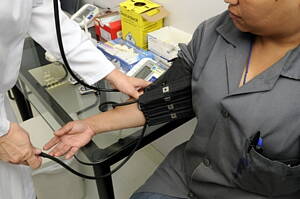 woman getting her blood pressure checked at a medical clinic