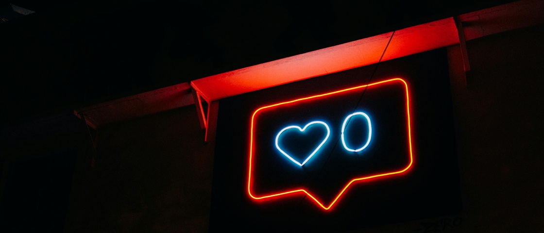 Neon light sign of heart and zero in a social media comment bubble