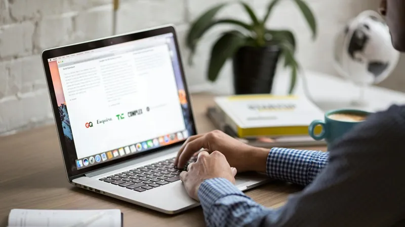 Person typing on a macbook laptop focused on writing content for email automation