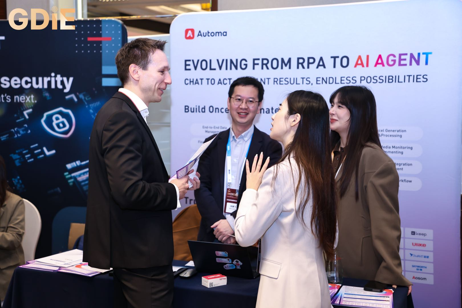 Automa team members engaging in a technical discussion with international innovators at the GDIE 2026 booth regarding the future of work and AI agents.