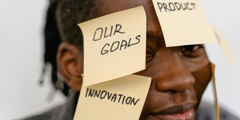Man covered in sticky notes representing business goals and innovation