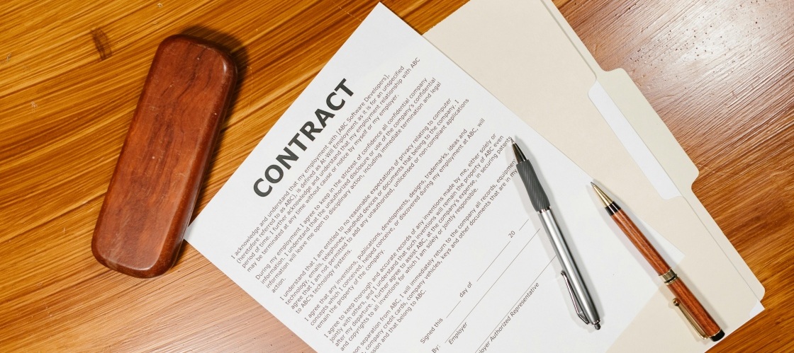 An employment contract on a desk, representing how data extraction automation streamlines legal document management.