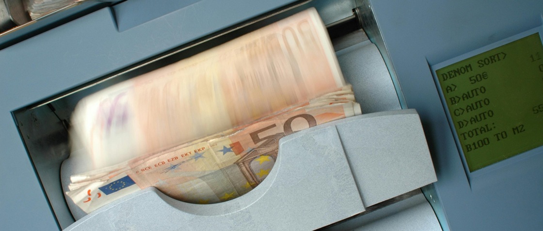 Money counting machine representing high-speed payouts and automated invoice processing efficiency.