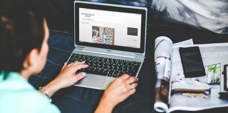 Woman working on a laptop in bed