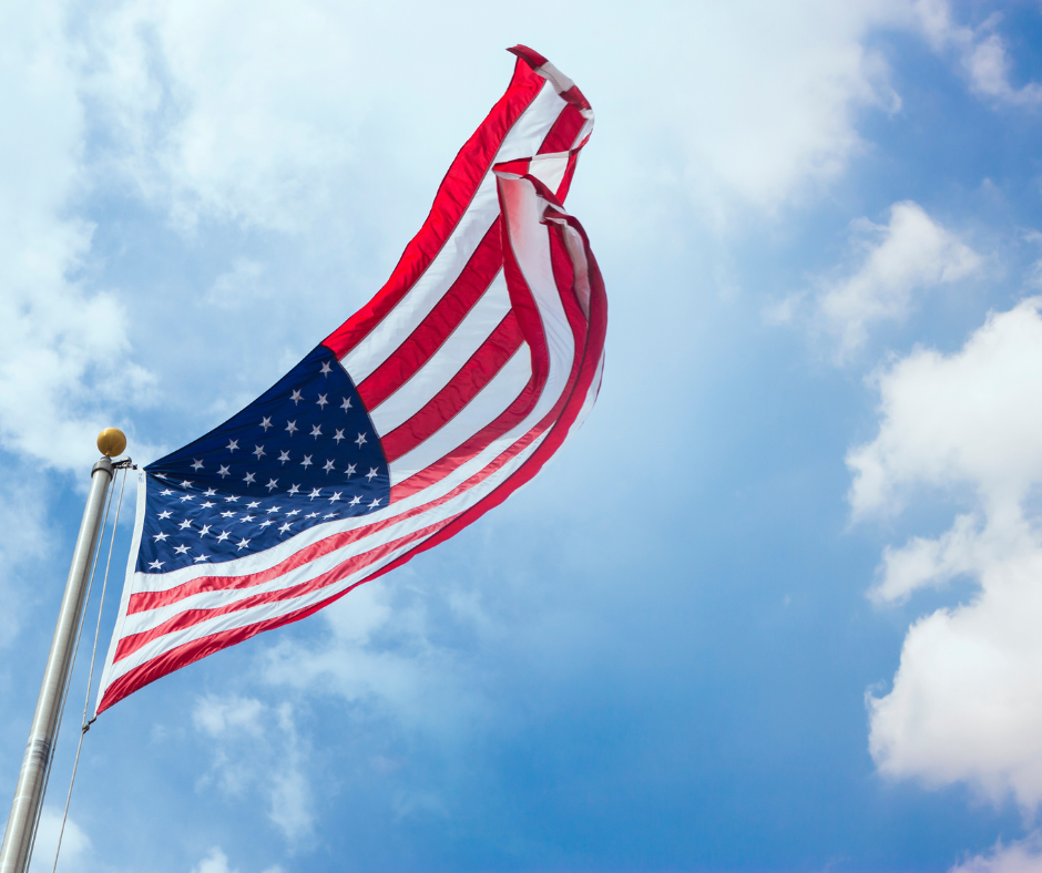 American flag waving in blue sky