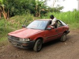 Kameroen Bimbia chauffeur klimt in auto