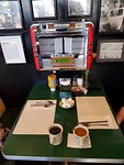 Mels diner. Iedere tafel heeft een eigen jukebox. Voor 25 dollarcent kies je een nummer.