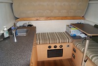 Binnenin de camper, achter het luchtbed ( dat bruine ding) is de rest van het bed