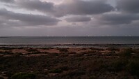Aan de horizon liggen de verlichte schepen als kerstverlichting te wachten.