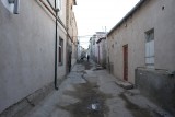 Een gewone straat buiten het centrum van Bukhara. Let op de goot in het midden.