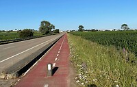 De kortere weg langs de verkeersweg.