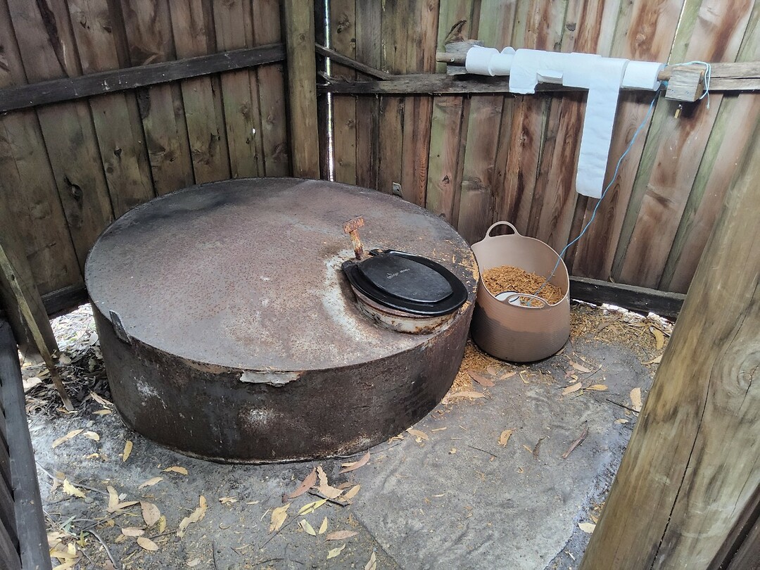 De wc met een bak stro ernaast.