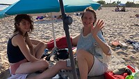 Onder een parasolletje, met een windje en de zee om in af te koelen…