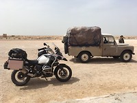 Onderweg bij een petit resto. Er rijden veen oude Landrovers rond