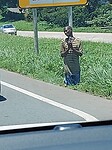 Bedelaar op zijn knieën langs de snelweg