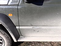 Sporen van de aressieve hond die springt op de autodeur al rijdend