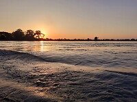 Over de Mekong terwijl de zon ondergaat 