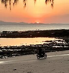 Scooter op strand bij zonsondergang
