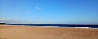 Uitgestrekt zandstrand