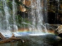 Regenboog gevormd aan de voet van de waterval