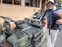 een historische legergroene Vespa scooter met zijspan