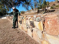 De muur bestaat uit lokale gesteenten die rijk zijn aan mineralen
