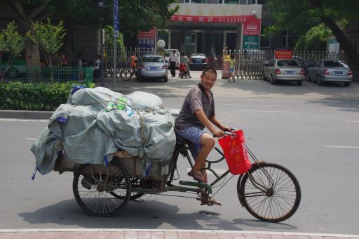 Man op fiets met troep achterop