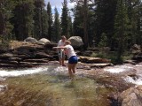 Brother helping sister to cross the river