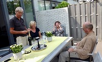 de champagne wordt ontkurkt in de tuin van Marian en Bert