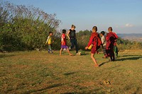 Denise is playing soccer with the local kids