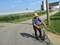 Amish man in traditionele kledij op ouderwetse fiets