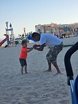 Oliver en papa stoeien strand