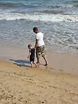 Papa en Oliver over het strand