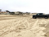 Met de auto het strand op