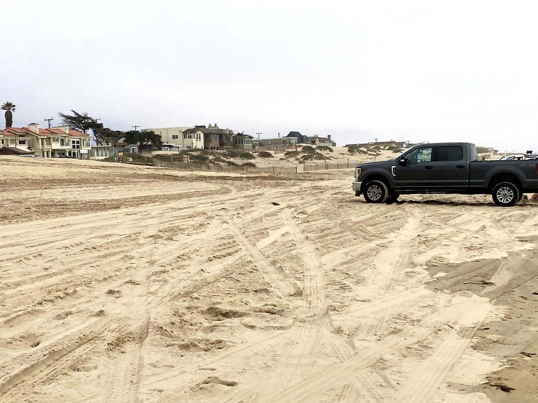 Met de auto het strand op
