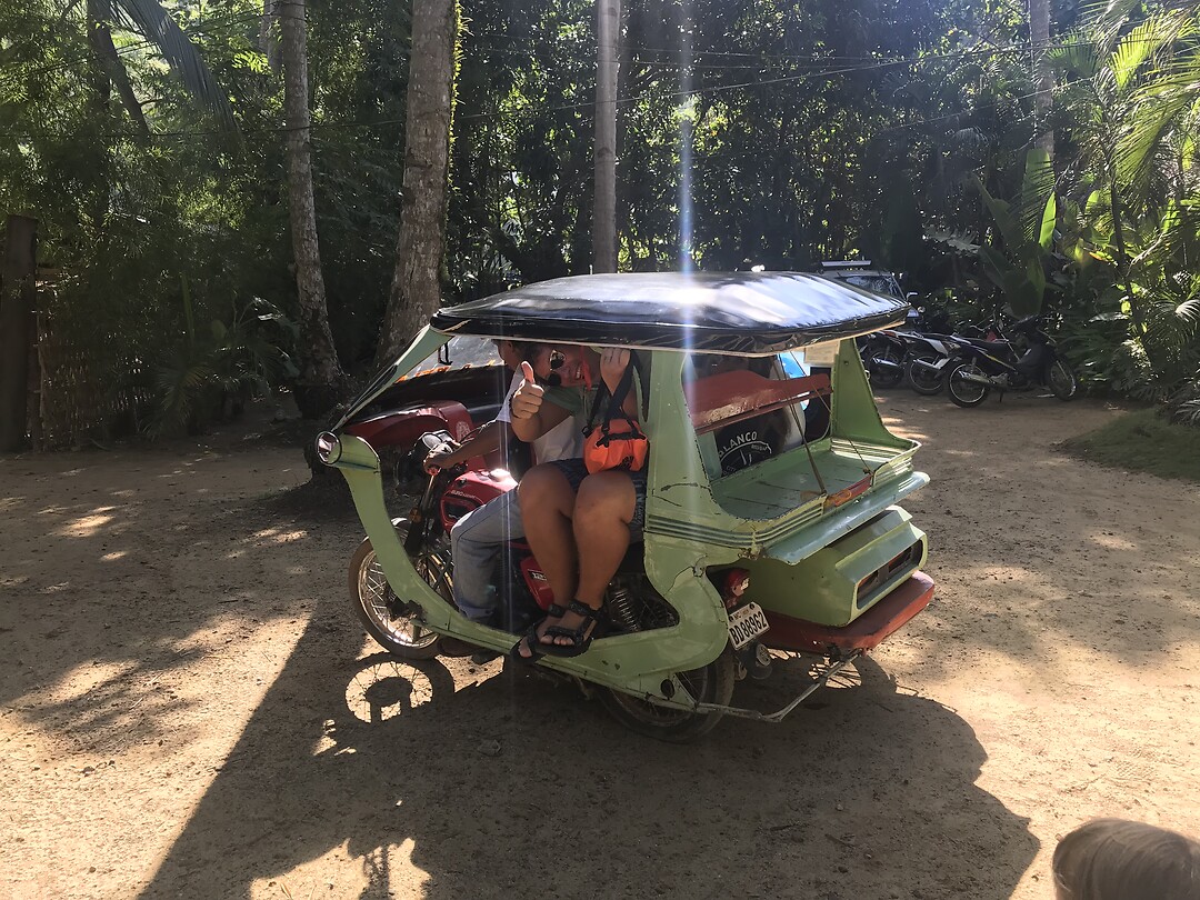 Opgevouwen in een tricycle op weg naar zijn eilandtour