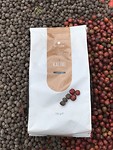 Het eindproduct Kalimi koffie samen met de gedroogde bessen, en de rode bessen