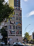 Schildering van een boekenkast op een flatgebouw in Tirana