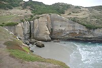 100 Tunnel Beach. Het kleine poortje in het midden is de tunnel die toegang geeft