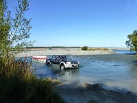 de vissers steken met hun 4 wheel-drives de rivier over