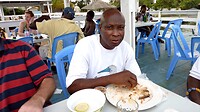 onze chauffeur geniet van de tilapia, hij eet met zijn vingers