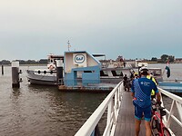 op fietsschoenen gaan we voorzichtig over de loopbrug naar het veer