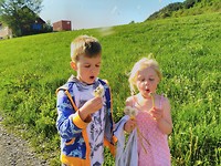 Vilje and Ilan blowing dandelions
