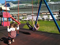 Ilan and Gwyn on the swing in front of a huge cruise ship in Flåm