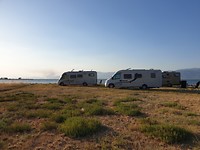 Op de achtergrond de bosbranden van schiereiland Evia