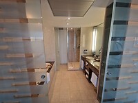 De badkamer met glazen schuifdeuren.