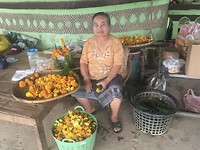 Deze dame maakt bloemstukjes voor de tempel