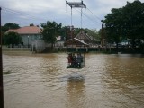 Kabelbaantje met 4 personen erin over rivier.